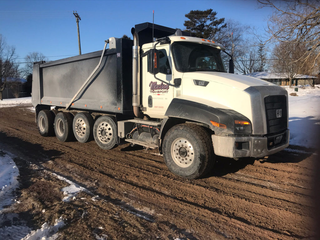 a white dump truck on fresh dirt