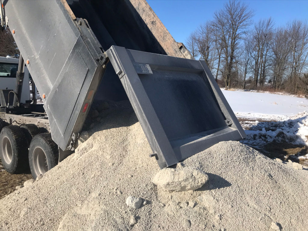 a dump truck unloads gravel