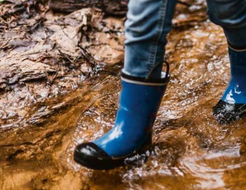 blue boots walk through water and mud